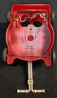 Red vintage plastic lawn mower salt & pepper shakers with white push handle, made in U.S.A. on black background.