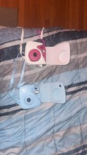 blue instax mini 75, pink mini 8 both. case and straps for holding. need film
