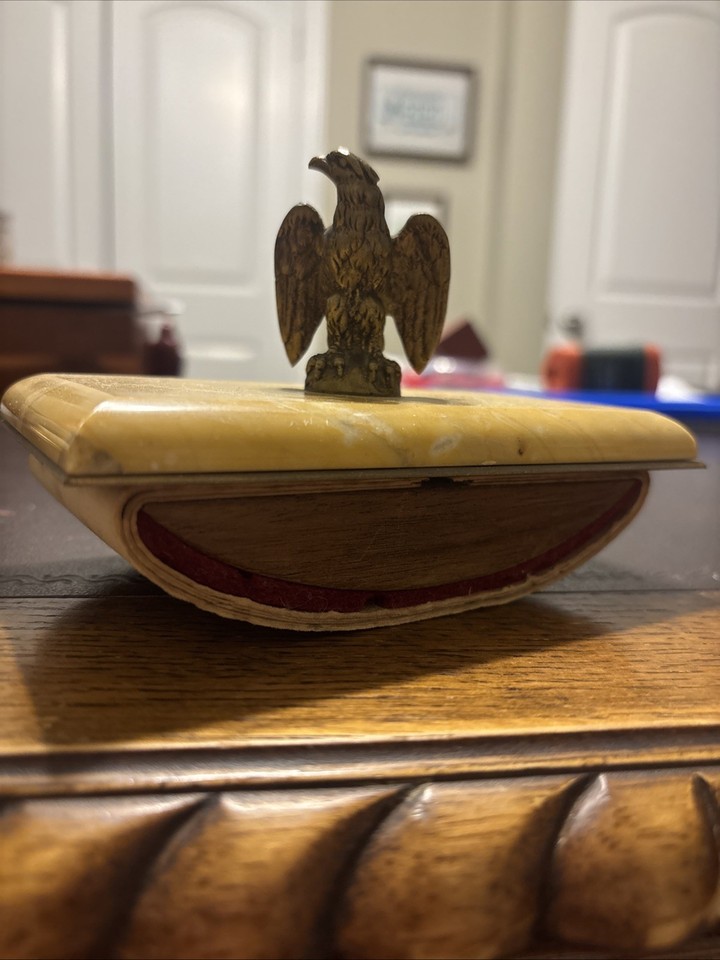 A rocking stone ink blotter crowned with a brass eagle — a pre-digital desk tool that doubles as serious executive sculpture.