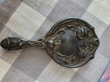 Art Nouveau silver-plated hand mirror decorated with floral designs.