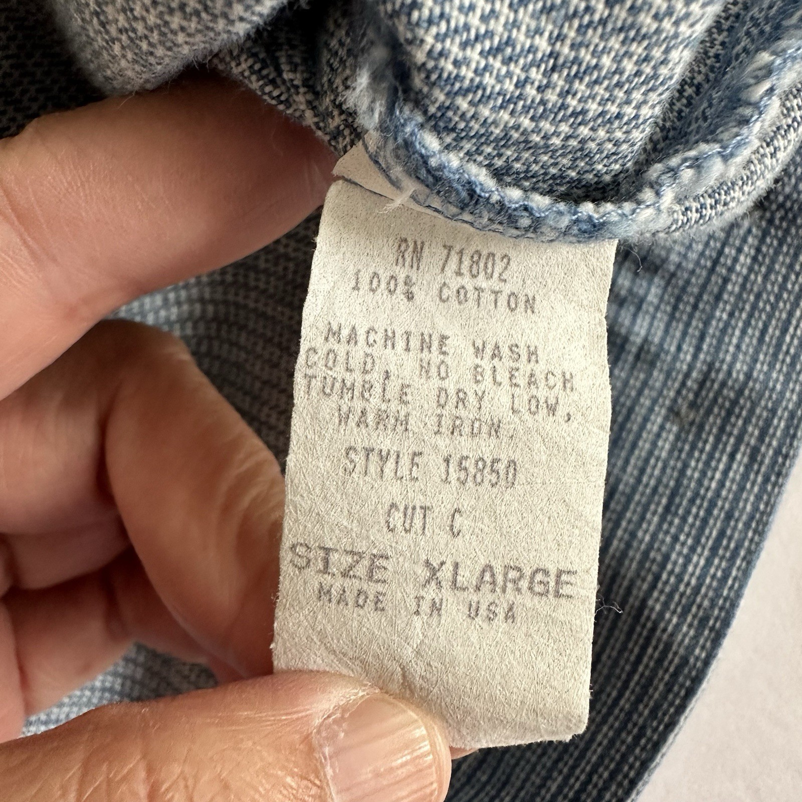 White vintage FSTOP label on blue denim vest, size XL, with yellow printed text and RN 71802 Made in U.S.A.