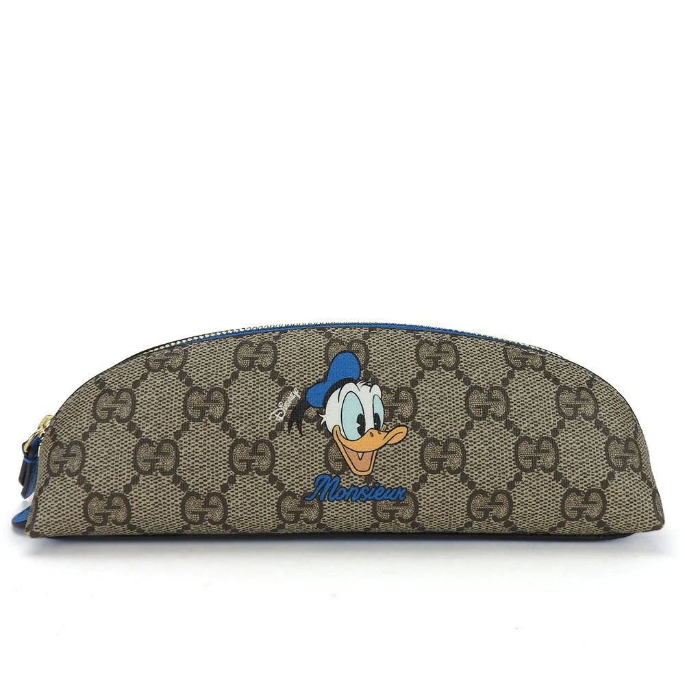 Pochette GUCCI D'OCCASION 662129 GG Supreme PVC beige Donald Duck