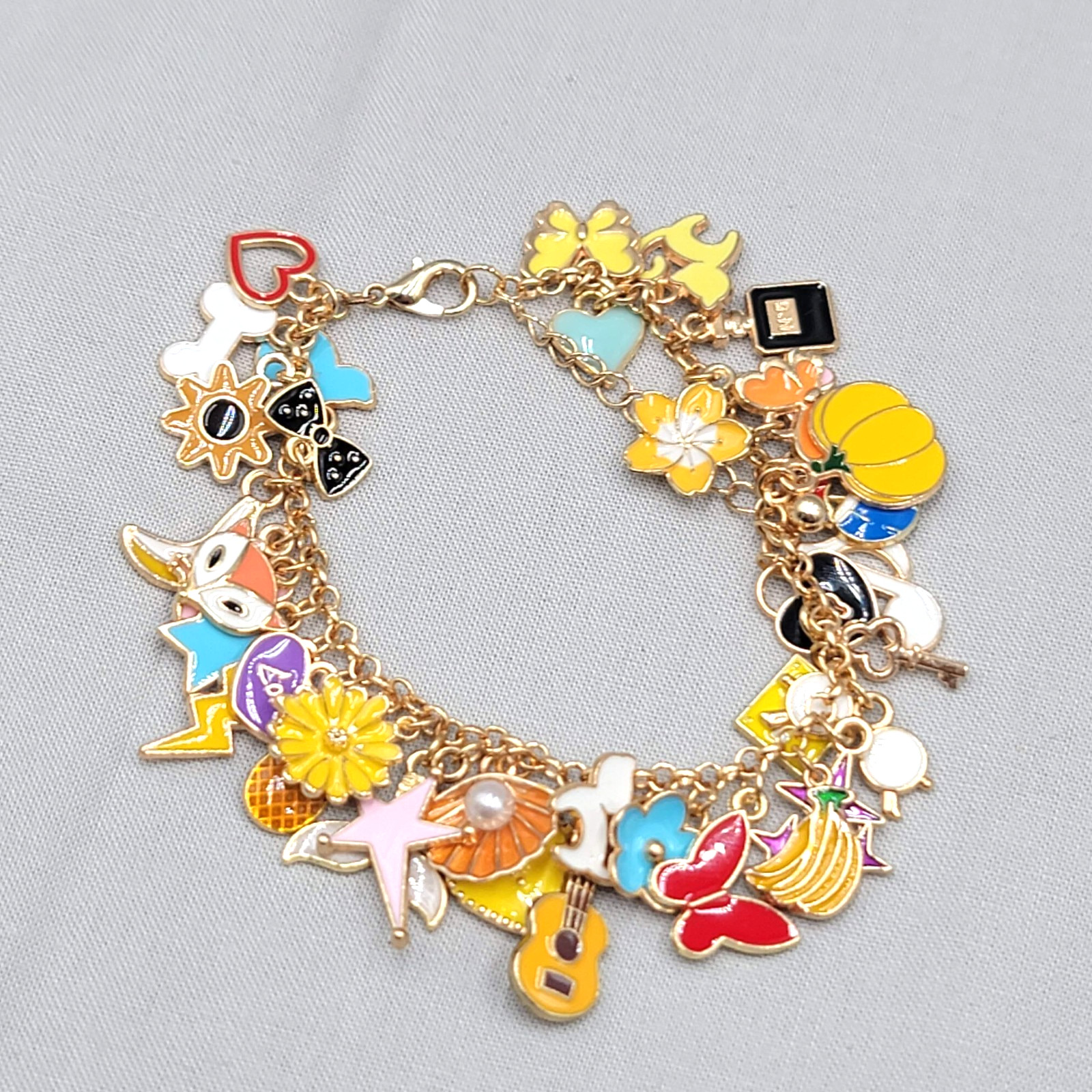 Gold-tone charm bracelet loaded with multicolor enamel dangle charms