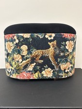 Creatures of Curiosity leopard print ottoman  amidst exotic florals