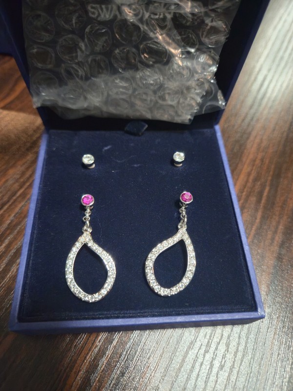 Swarovski pierced earrings with clear and fuchsia crystals, featuring a...