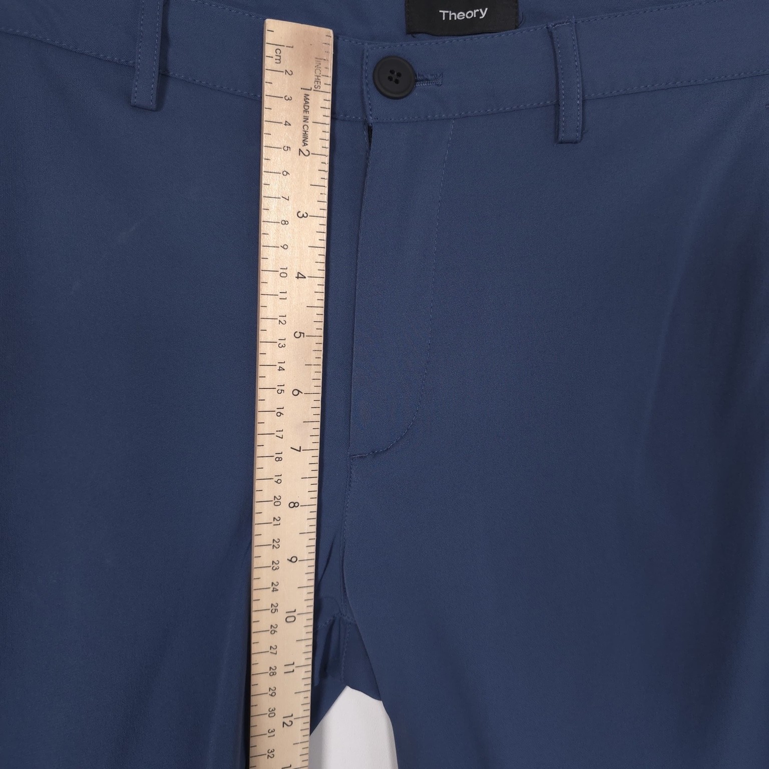 Blue 32 slim-fit Theory men’s dress pants with front button closure, side pockets, and measuring tape across the waistband.