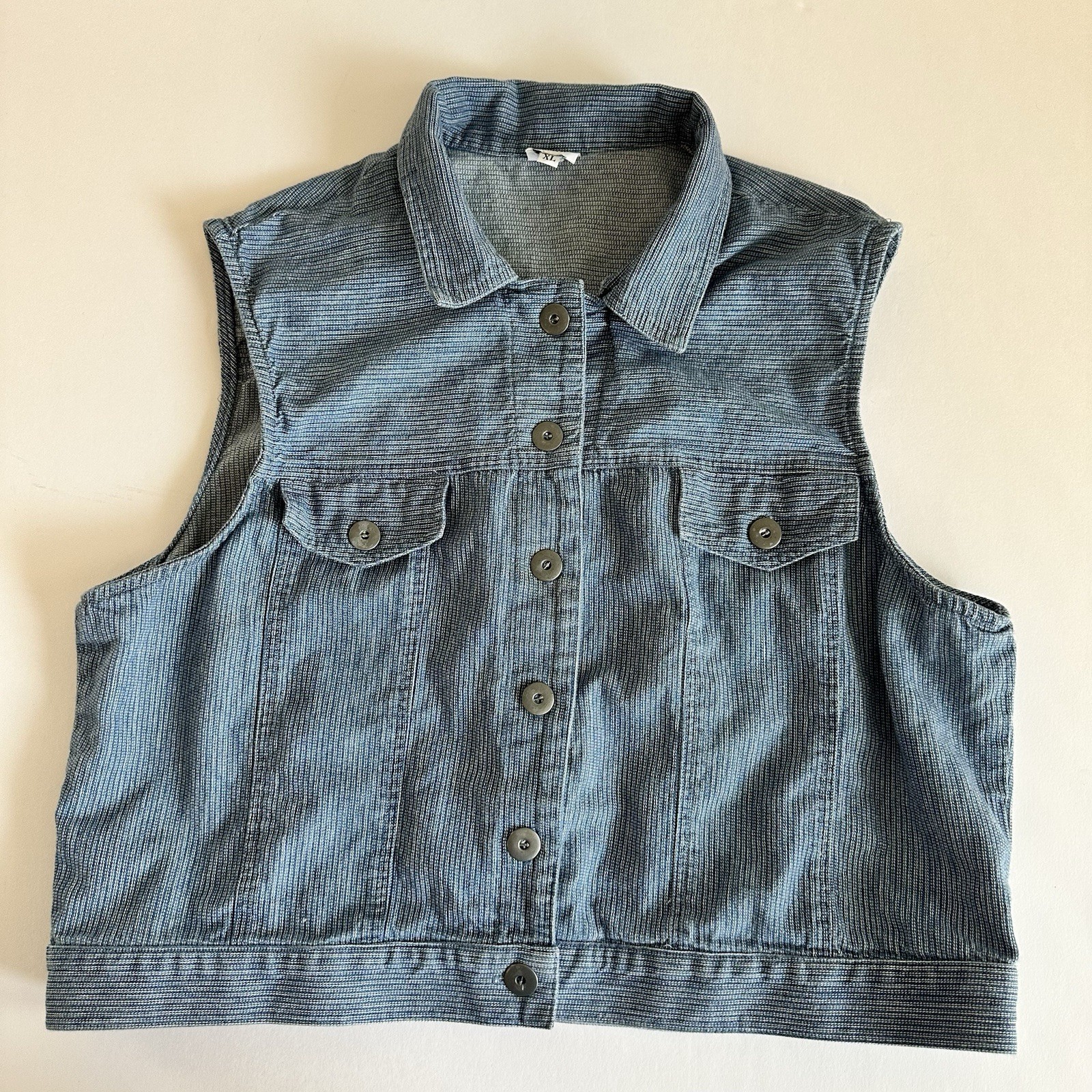 Vintage blue cotton denim vest XL with front snap buttons, pointed collar, and two front flap pockets made in USA.