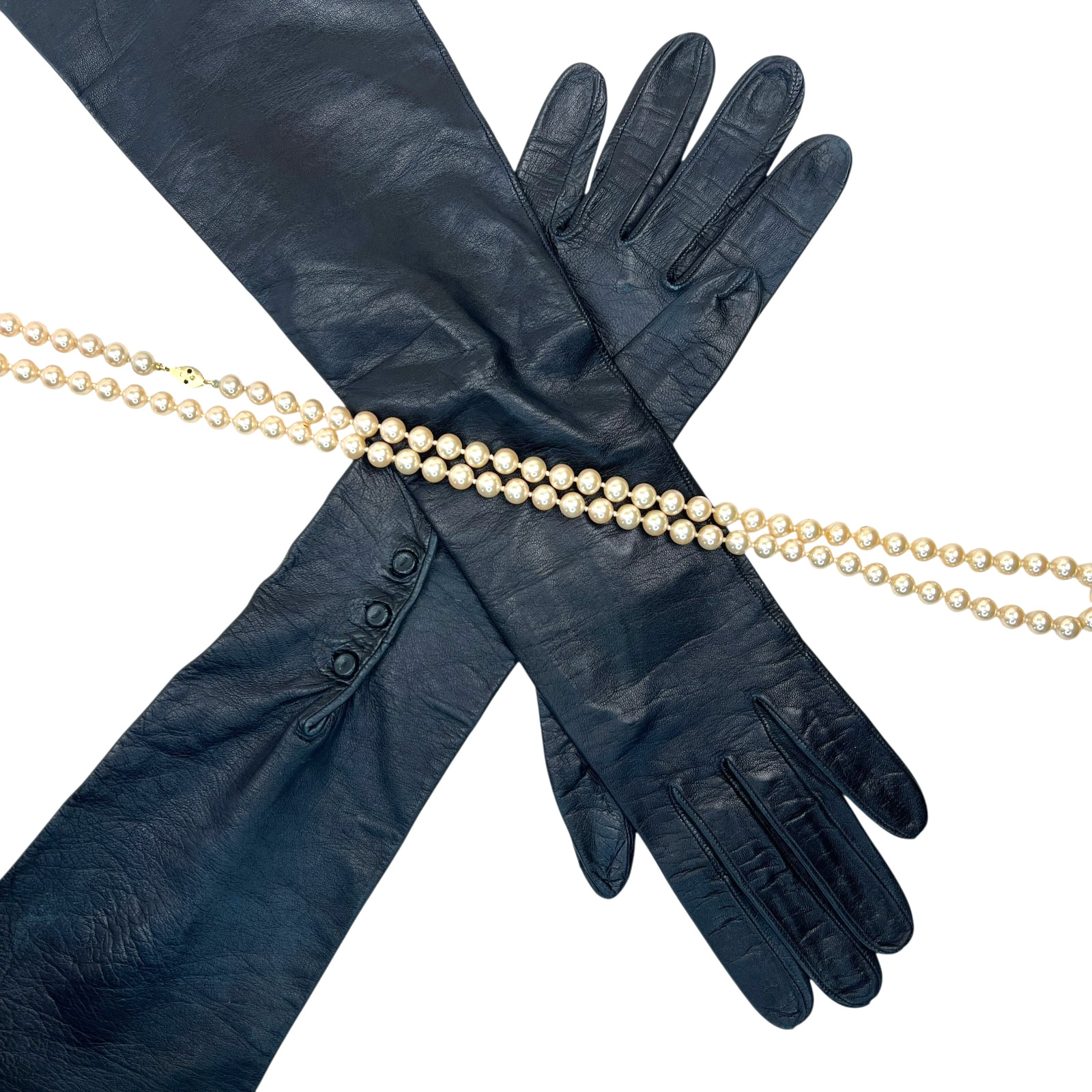 Pair of navy blue leather opera gloves crossed on a white background.