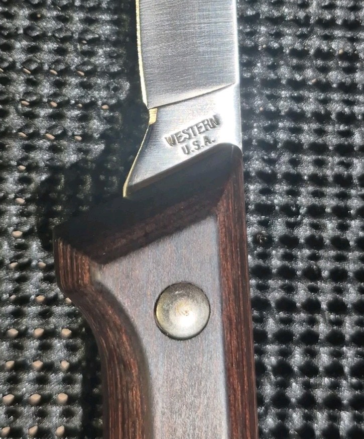 Vintage Western fish fillet knife with steel blade, wooden handle, brass screw, and silver engraving reading “W.E.S.T.ERN U.S.A.”