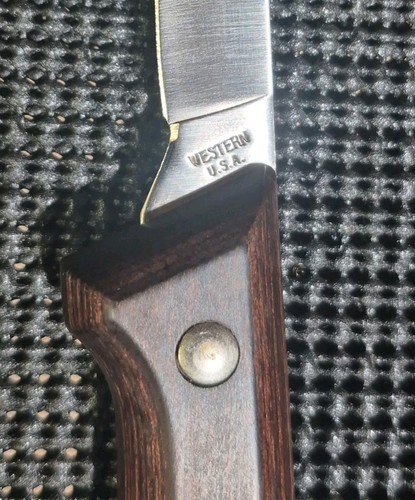 Vintage Western fish fillet knife with steel blade, wooden handle, brass screw, and silver engraving reading “W.E.S.T.ERN U.S.A.”