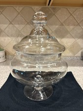 Clear glass footed apothecary jar with a matching knobbed lid