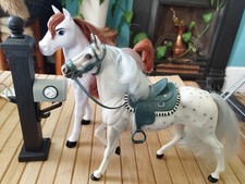 A Pair of Toy Horses One with A Saddle and The Other From The Spirit Riding Free