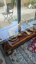 Large glass table top with a gold panther sat on wooden fixing. 