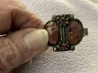 A Vintage Costume Jewelry Piece With Purple Stones On Dark Metal Pendant