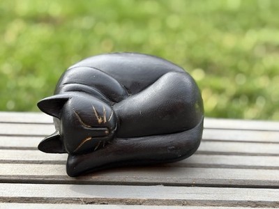 Vintage schwarze, handgeschnitzte schlafende Katze aus Holz goldbemalt Details im Gesicht