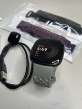 Fitbit Versa 4 smartwatch with charger and ac...