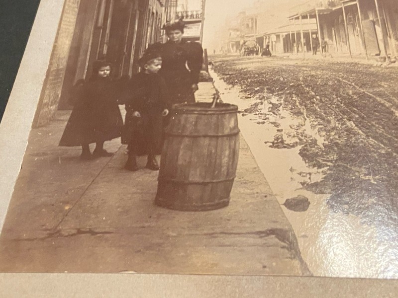 Early New Orleans Picture A Woman And Two Children By A Barrel On A Muddy Street