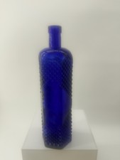 Vintage cobalt blue glass bottle with a textured hexagonal diamond pattern.
