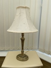 A Table Lamp in an Antique Brass Finish With Cream Shade