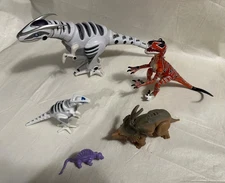 toy dinosaurs, 5 of various sizes, different brands and types, 4 are jointed