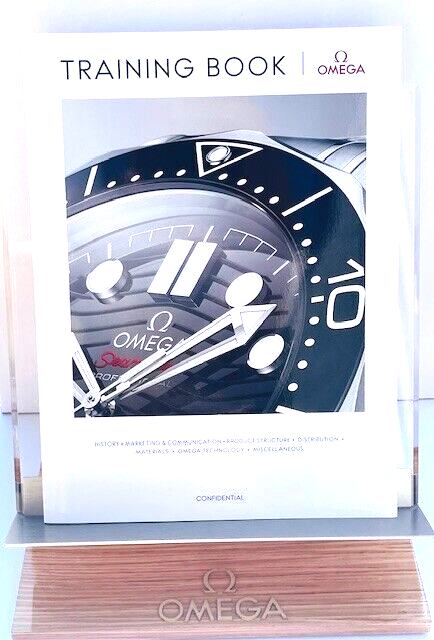 OMEGA WATCH WOOD/ACRYLIC DISPLAY STAND, TRAINING BOOK & LIMITED EDITION MAGAZINE