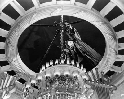 Claude Rains attempts to cut a chain holding a chandelier a scene - Old Photo