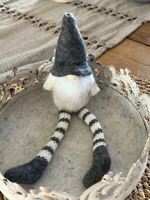 Sitzender grauer Gonk mit baumelnden Beinen