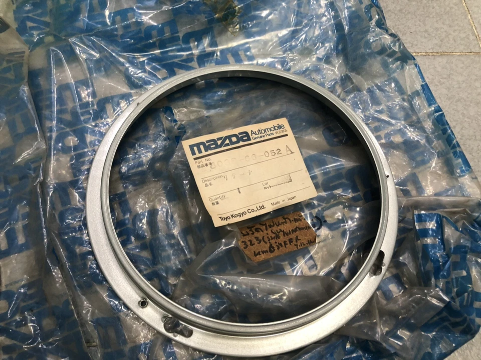 Mazda 323 1977-79 primera generación FARO ANILLOS ENVOLVENTES ADORNOS NOS Genuino JP 1 Par Foto 4 de 4