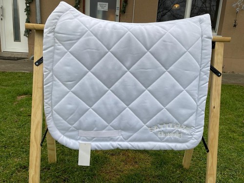 Weiße Dressurschabracke mit Logo der Sattlerei Hennig