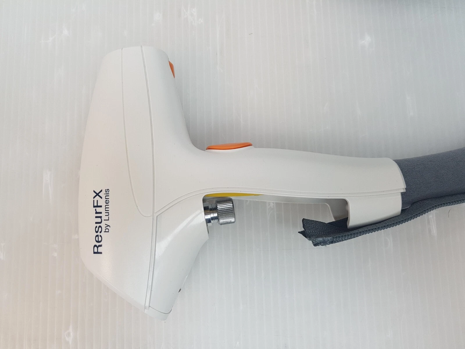 Side of the ResurFX by Lumenis handpiece with orange button