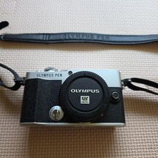 The OLYMPUS PEN E-P7 features a stylish silver and black design.