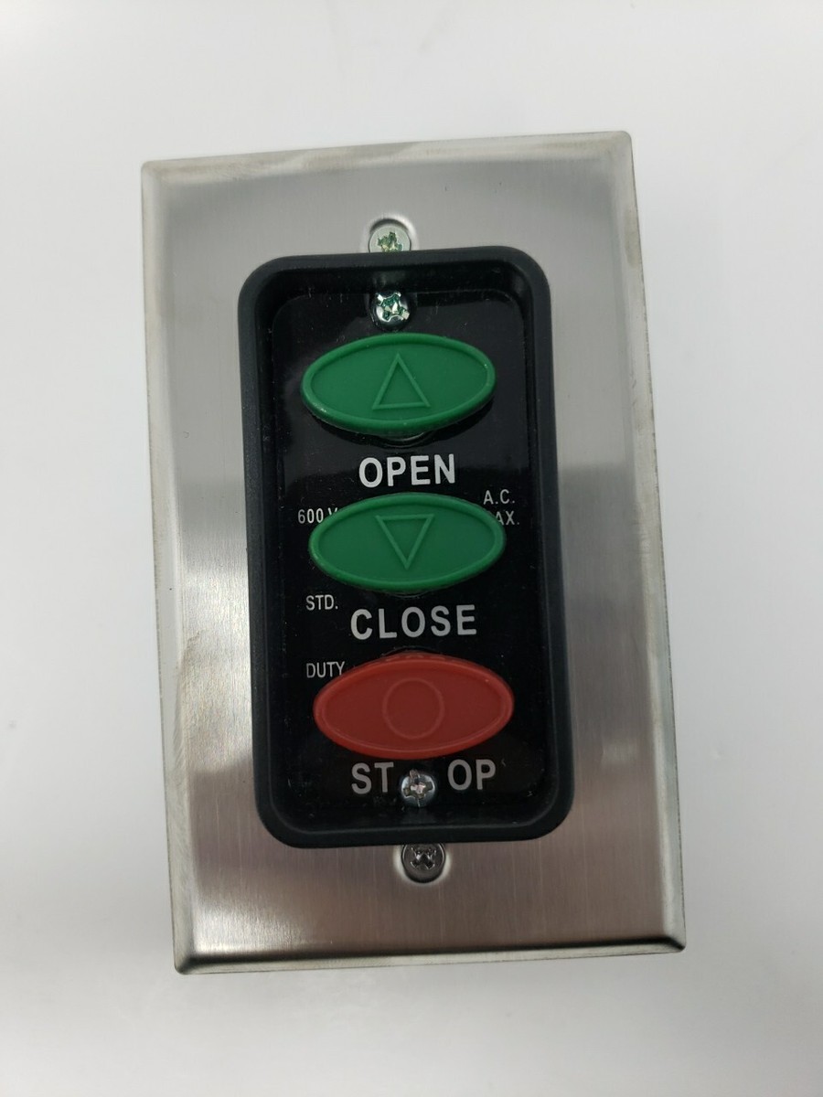 Hand opening the cover of a garage door wall button
