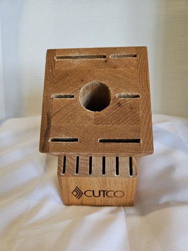 Rectangular wooden CUTCO knife storage block with 13 slots and a central circular hole, logo on black side.