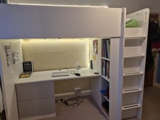 bunk bed with a desk underneath and a wardrobe on it
