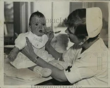 1935 Press Photo Nurse De Kiriline looks for Baby Ceciles teeth - nera11724