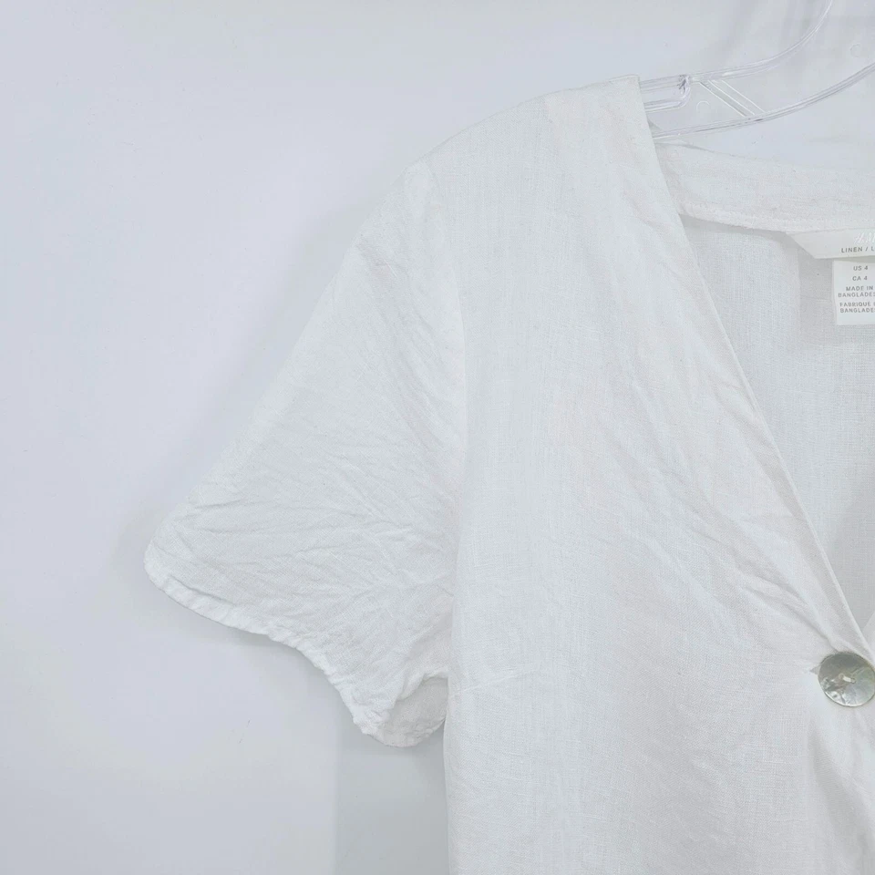 Top envolvente H&M 100 % lino peplum 4 botones blancos recortados madreperla lazo cintura Foto 3 de 4