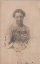 RPPC postcard Woman Holding a Fan Looking Wistful