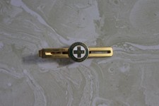 VINTAGE GOLDTONE/ENAMEL TIE BAR FROM MERCK GREEN CROSS FOR SAFETY
