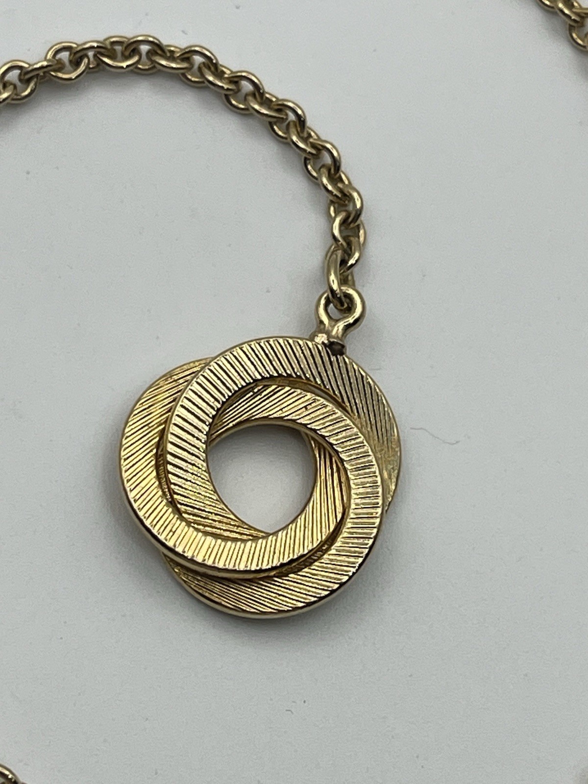 Engine turned gold tone triple interlocking circl… - image 9