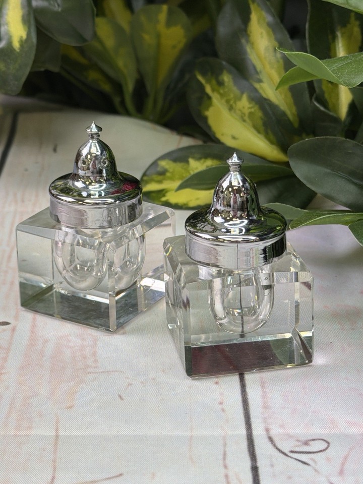 A matching pair of clear glass inkwells with original chrome lids — a sleek, usable piece of mid-century desk theatre.