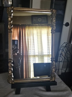 Vintage- style gold framed mirror with ornate Baroque-inspired design
