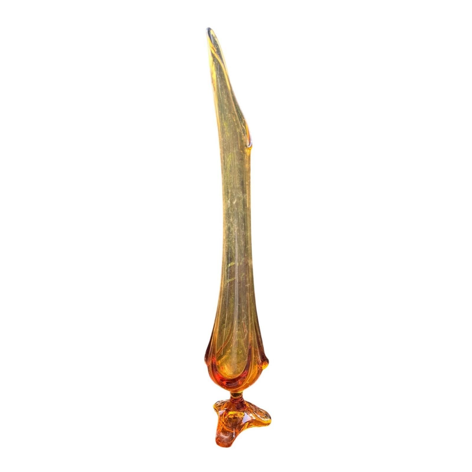 Tall amber swung art glass floor vase with a tripod foot on a white background.