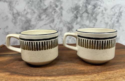 Two beige LENOX Temper Ware coffee mugs with black horizontal stripes, gold vertical text, and black rim accents.