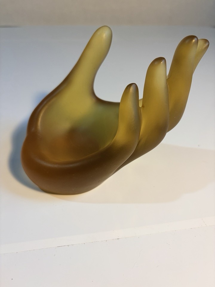 Frosted amber resin hand sculpture doubling as a jewelry display — peak MCM eeriness meets functional elegance, basically a tiny art object for your vanity.