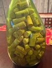 Unique shaped green vase filled with wine corks — photo 5