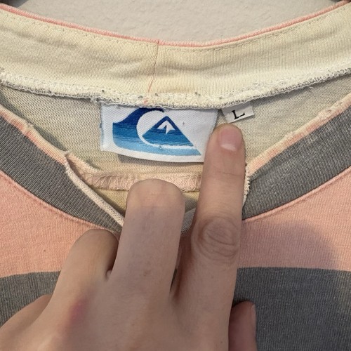 Close-up of vintage Roxy men’s shirt, size L, with blue and white logo patch on front and pink-gray horizontal stripes.