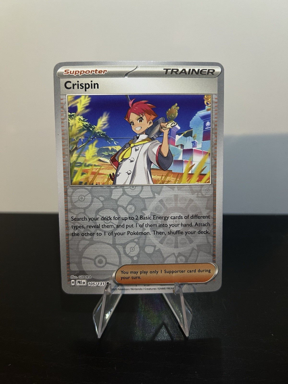 Crispin 105/131 Reverse Holo Pokemon Prismatic Evolutions NM