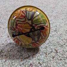 Vintage T Cohn tin noise maker collectible, festive bells graphics, wood handle