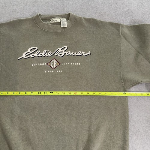 Olive green vintage Eddie Bauer sweatshirt size L with white “Outdoor Hip Hop USA Made 90s” text and red eagle logo on chest.