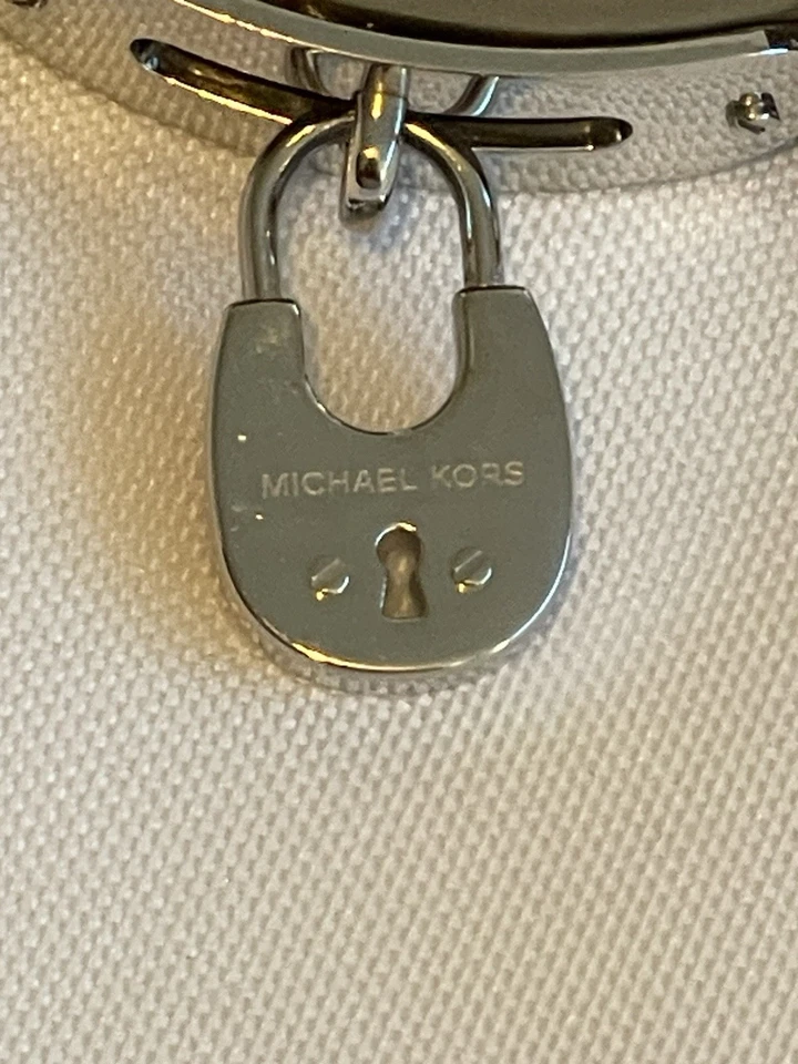 Pulsera Michael Kors de cuero marrón en tono dorado y plateado con bloqueo/cartera colgante Foto 2 de 4